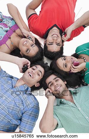 Stock Photography - High angle view of friends talking on mobile phones. Fotosearch