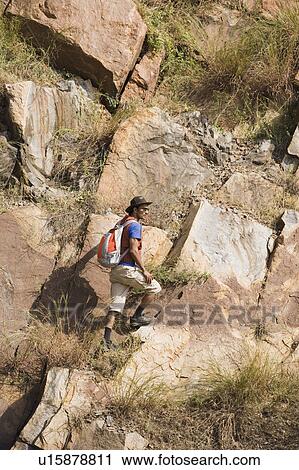 Hiker climbing on rocks View Large Photo Image Stock Image - Hiker climbing on rocks. Fotosearch