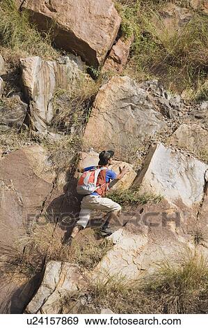 Stock Photo - Hiker climbing on rocks. Fotosearch