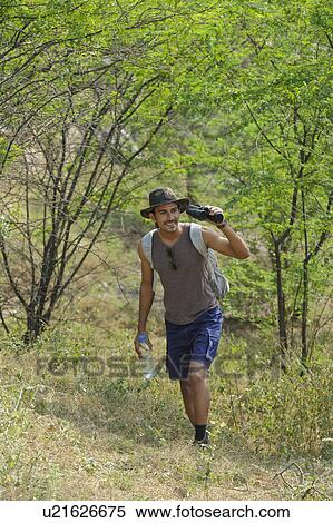 Stock Photography - Hiker looking through binoculars in a forest. Fotosearch