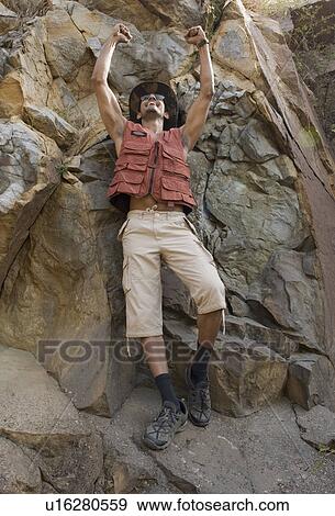 Hiker on rocks with his arms raised View Large Photo Image Stock Photo - Hiker on rocks with his arms raised. Fotosearch