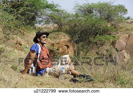 Stock Photo - Hiker sitting in a forest. Fotosearch
