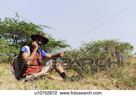 Hiker talking on a mobile phone View Large Photo Image Stock Image - Hiker talking on a mobile phone. Fotosearch