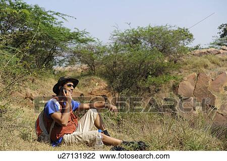 Hiker talking on a mobile phone View Large Photo Image Stock Image - Hiker talking on a mobile phone. Fotosearch