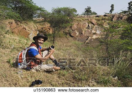 Stock Image - Hiker text messaging on a mobile phone. Fotosearch