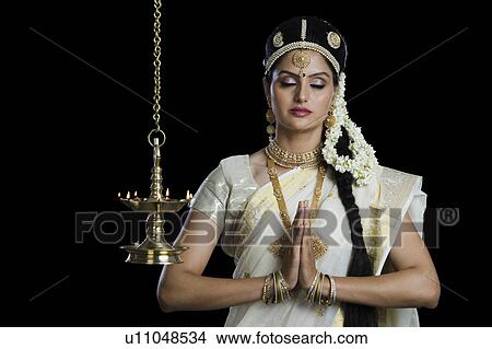 Indian woman in traditional clothing praying at Durga puja festival View Large Photo Image Picture - Indian woman in traditional clothing praying at Durga puja festival. Fotosearch