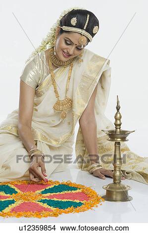 Indian woman in traditional clothing making rangoli at Durga festival View Large Photo Image Picture - Indian woman in traditional clothing making rangoli at Durga festival. Fotosearch