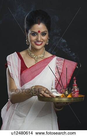 Indian woman in traditional clothing holding religious offering View Large Photo Image Picture - Indian woman in traditional clothing holding religious offering. Fotosearch