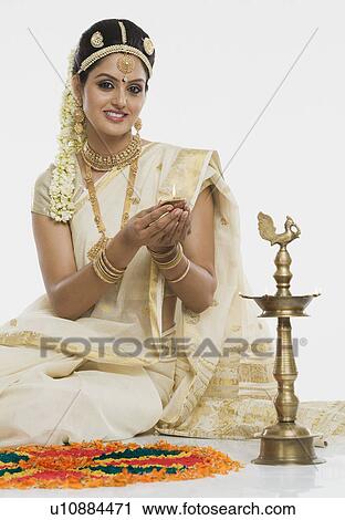 Indian woman in traditional clothing lighting an oil lamp View Large Photo Image Stock Image - Indian woman in traditional clothing lighting an oil lamp. Fotosearch