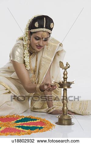 Indian woman in traditional clothing lighting an oil lamp View Large Photo Image Stock Image - Indian woman in traditional clothing lighting an oil lamp. Fotosearch