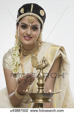 Indian woman in traditional clothing lighting an oil lamp View Large Photo Image Stock Image - Indian woman in traditional clothing lighting an oil lamp. Fotosearch