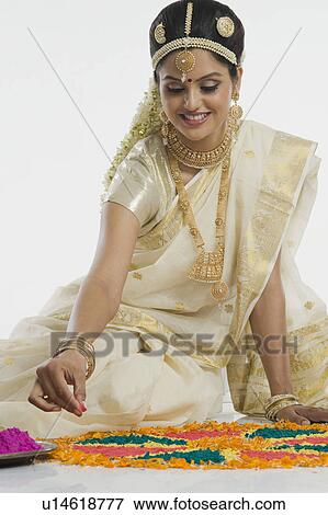Indian woman in traditional clothing making rangoli at Durga festival View Large Photo Image Stock Photo - Indian woman in traditional clothing making rangoli at Durga festival. Fotosearch