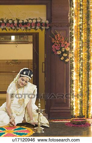 Indian woman in traditional clothing making rangoli at Durga festival View Large Photo Image Stock Photograph - Indian woman in traditional clothing making rangoli at Durga festival. Fotosearch
