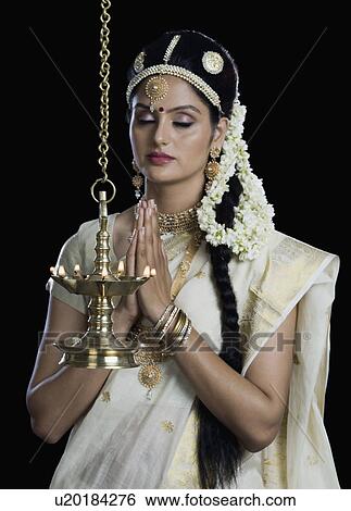 Indian woman in traditional clothing praying at Durga puja festival View Large Photo Image Stock Photograph - Indian woman in traditional clothing praying at Durga puja festival. Fotosearch