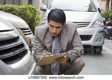 Insurance adjuster inspecting a car View Large Photo Image Stock Image - Insurance adjuster inspecting a car. Fotosearch