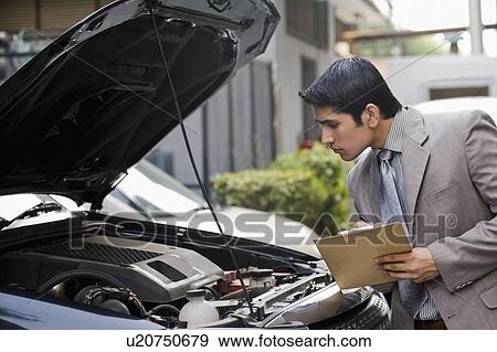 Stock Photo - Insurance adjuster inspecting a car. Fotosearch