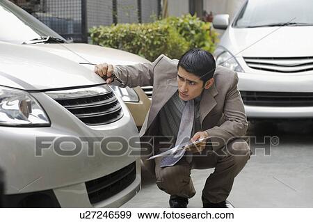 Insurance adjuster inspecting a car View Large Photo Image Stock Photo - Insurance adjuster inspecting a car. Fotosearch