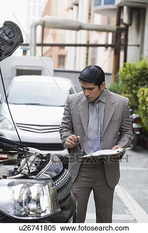 Stock Photography - Insurance adjuster inspecting a car. Fotosearch