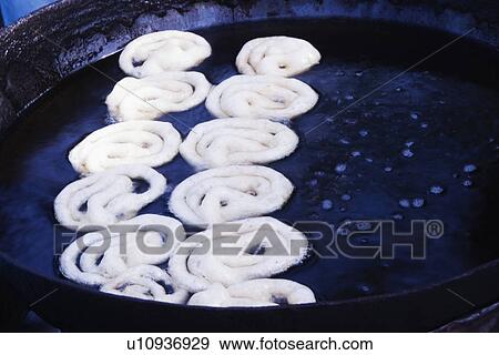 Stock Photo - Jalebis (An Indian traditional sweet food) preparing at a market stall, Delhi, India. Fotosearch