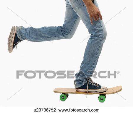 Stock Image - Low section view of a man skateboarding. Fotosearch