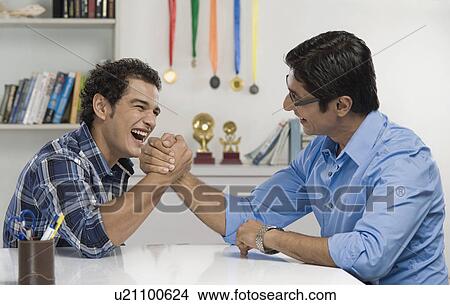 Picture - Man and his father arm wrestling. Fotosearch