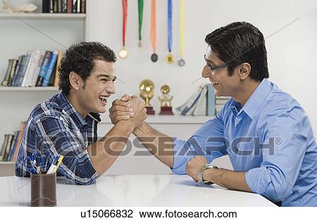 Stock Image - Man and his father arm wrestling. Fotosearch