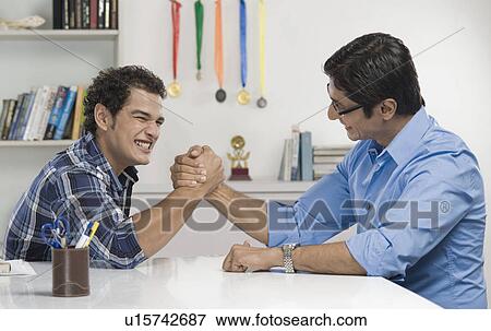 Stock Photo - Man and his father arm wrestling. Fotosearch