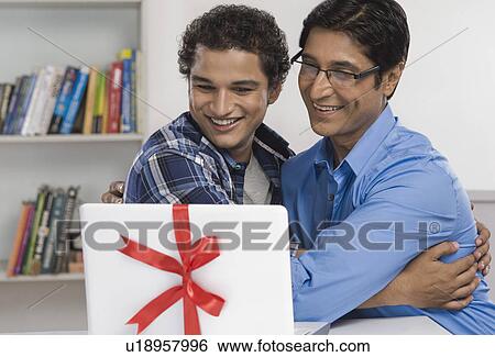 Man and his son hugging each other and smiling View Large Photo Image Stock Photograph - Man and his son hugging each other and smiling. Fotosearch