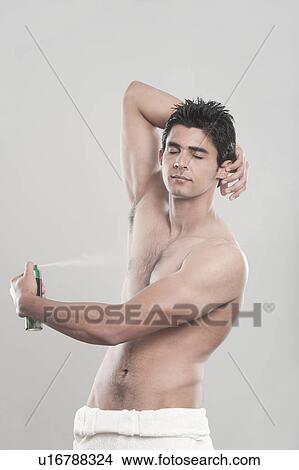 Man applying deodorant over his body View Large Photo Image Picture - Man applying deodorant over his body. Fotosearch