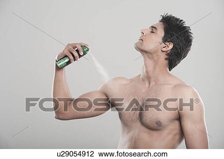 Stock Image - Man applying deodorant over his body. Fotosearch