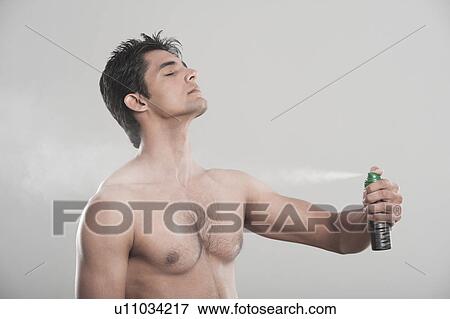 Man applying deodorant over his body View Large Photo Image Stock Photo - Man applying deodorant over his body. Fotosearch