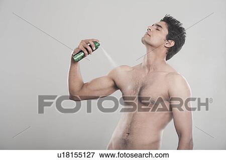 Man applying deodorant over his body View Large Photo Image Stock Photo - Man applying deodorant over his body. Fotosearch