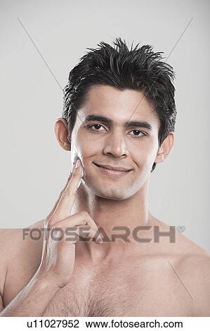 Man applying moisturizer on his face View Large Photo Image Stock Image - Man applying moisturizer on his face. Fotosearch