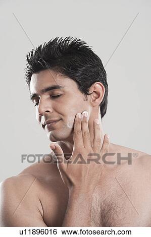 Man applying moisturizer on his face View Large Photo Image Stock Photograph - Man applying moisturizer on his face. Fotosearch