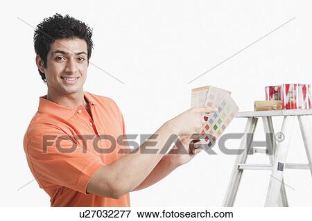 Man choosing paint from color swatches for his house View Large Photo Image Stock Photo - Man choosing paint from color swatches for his house. Fotosearch