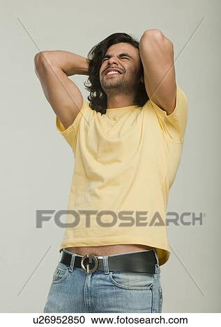 Man clenching teeth with his hands behind head View Large Photo Image Stock Image - Man clenching teeth with his hands behind head. Fotosearch