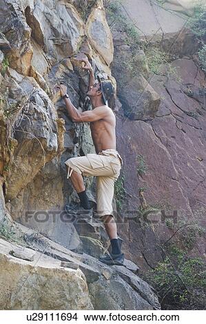 Picture - Man climbing on rocks. Fotosearch
