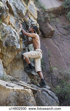 Man climbing on rocks View Large Photo Image Stock Image - Man climbing on rocks. Fotosearch