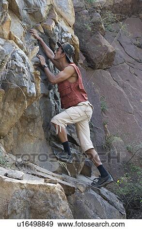 Man climbing on rocks View Large Photo Image Stock Photo - Man climbing on rocks. Fotosearch
