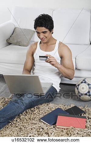 Stock Image - Man doing online shopping with a laptop. Fotosearch
