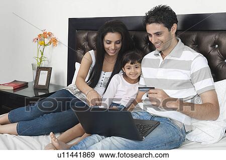 Man doing online shopping with his family View Large Photo Image Stock Photo - Man doing online shopping with his family. Fotosearch
