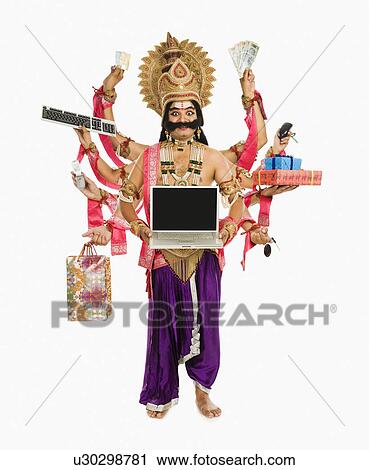 Stock Image - Man dressed-up as Ravana the demon king holding gifts. Fotosearch