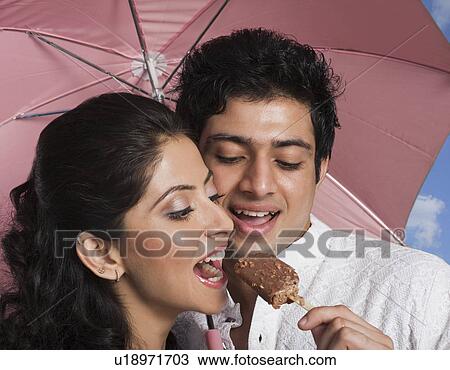 Man feeding an ice cream to a woman View Large Photo Image Stock Image - Man feeding an ice cream to a woman. Fotosearch