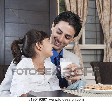 Man feeding milk to his daughter View Large Photo Image Stock Photo - Man feeding milk to his daughter. Fotosearch