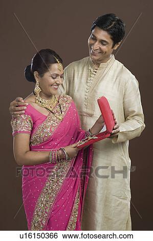 Man giving a jewelry box to his wife in present View Large Photo Image Stock Photograph - Man giving a jewelry box to his wife in present. Fotosearch