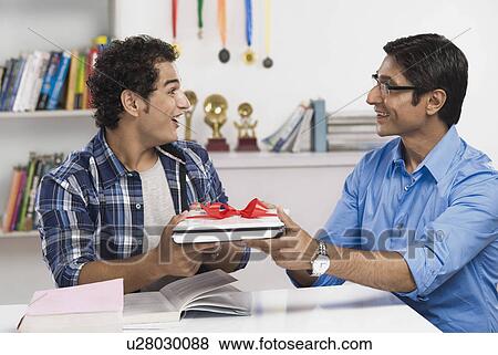 Man giving a laptop in gift to his son View Large Photo Image Stock Photo - Man giving a laptop in gift to his son. Fotosearch