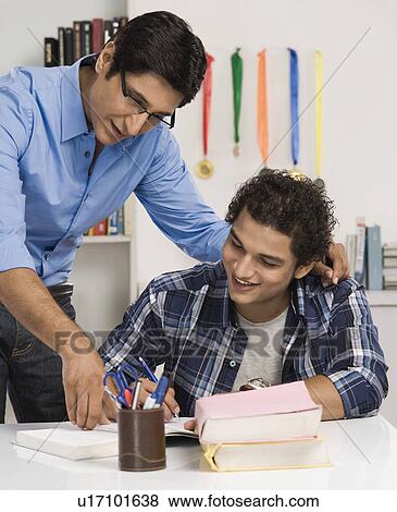 Man helping his son in study View Large Photo Image Stock Photo - Man helping his son in study. Fotosearch