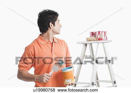 Stock Photo - Man holding a paint can. Fotosearch