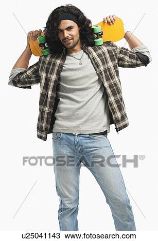 Man holding a skateboard on his shoulders View Large Photo Image Stock Image - Man holding a skateboard on his shoulders. Fotosearch