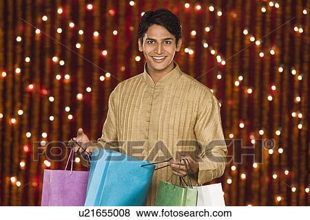 Stock Photo - Man holding shopping bags. Fotosearch